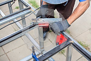 worker welds the steel structure at the construction site