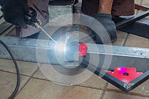 worker welds the steel structure at the construction site