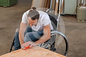 Worker in wheelchair in a carpenter`s workshop