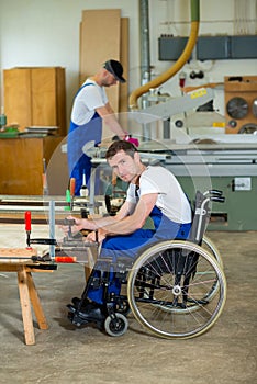 Worker in wheelchair in a carpenter's workshop