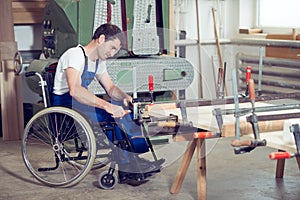 Worker in wheelchair in a carpenter's workshop