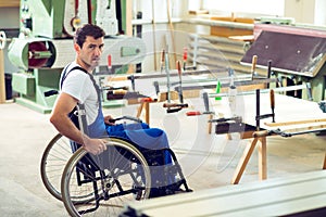 Worker in wheelchair in a carpenter's workshop