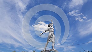 Worker woman historical monument on blue sky with white clouds background. Social realism sculpture in Odessa region of Ukraine