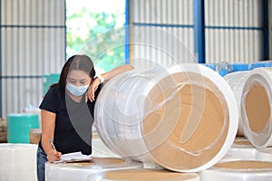 Worker woman  with mask on face she are checking stock at  warehouse