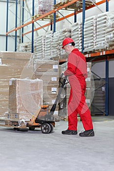 Worker at work with hand powered pallet jack