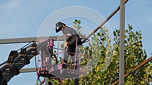 worker, worker welding steel construction on boom lift