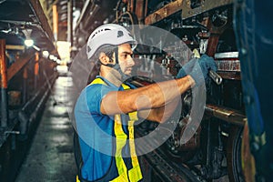 worker working in industrial factory uses a cross screwdriver to inspect the machine