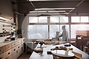 Worker working on lathe in workshop