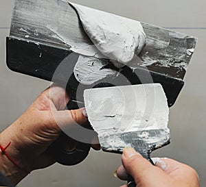 Worker working manual with wall plastering tools inside a house