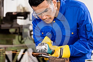 Worker working on metal with grinder tool