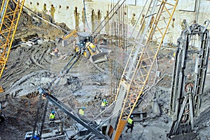 Worker working at pile driver works to set precast concrete piles in a construction high building area