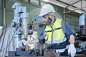 Worker is working in a steel factory. Engineer with monitor checking quality result of work