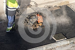 Worker working with a vibrating plate compactor machine