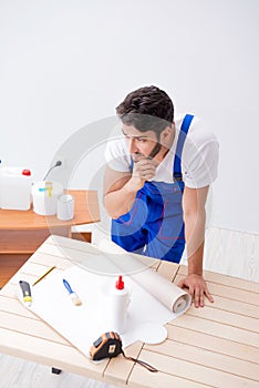 The worker working on wallpaper during refurbishment