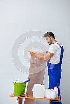 The worker working on wallpaper during refurbishment