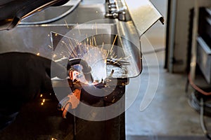 Worker working welding a metal with sparkle using a welding machine semi automatic argon gas shielded welding