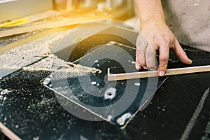 Worker works on woodworking equipment. Manufacturing of wooden furniture. Workshop for the production of wooden products