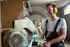 Worker in the workshop cuts the pvc profile