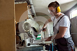 Worker in the workshop cuts pvc profile