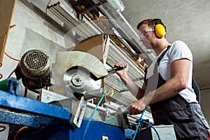 Worker in the workshop cuts pvc profile