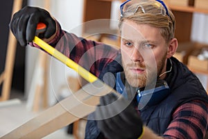 worker in workshop measuring metal