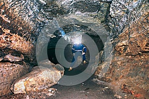 Workerman with helmet and protective suit using glowes and strong head lamp.