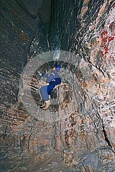 Workerman with helmet and protective suit using glowes and strong head lamp. Man do job