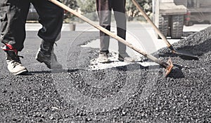 Workers arranging asphalt. Road construction. Industry