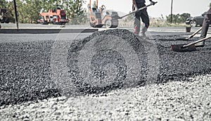 Workers arranging asphalt. Road construction. Industry