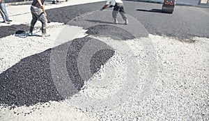 Workers arranging asphalt. Road construction. Industry