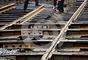 Workers assemble wooden sleepers and tram rails during the repair of city roads.