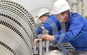 Workers assembling and quality control of gas turbines in a mode