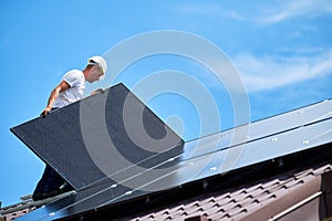 Workers building solar panel system on roof of house. Men installing photovoltaic solar module