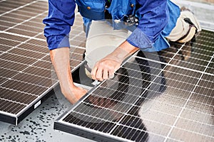 Workers building solar panel system on roof of house. Men installing photovoltaic solar module