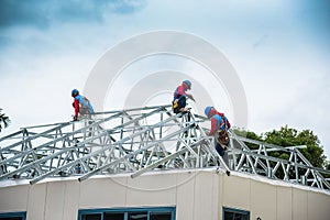 Workers are building a steel roof frame on high.