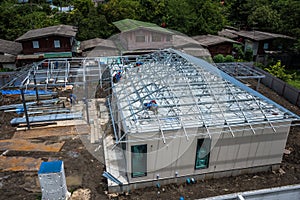 Workers are building a steel roof frame on high.