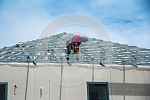 Workers are building a steel roof frame on high.