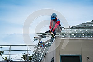 Workers are building a steel roof frame on high.