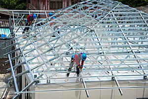 Workers are building a steel roof frame on high.