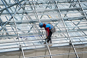 Workers are building a steel roof frame on high.