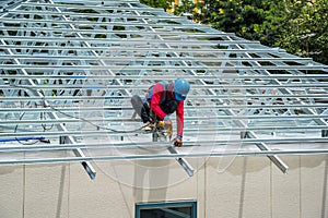 Workers are building a steel roof frame on high.