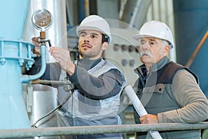 Workers calibrating industrial machine