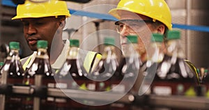 Workers checking bottles on production line