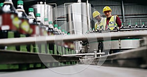 Workers checking bottles on production line