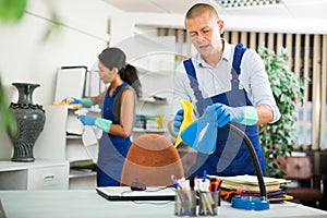 Workers cleaning desk in modern office