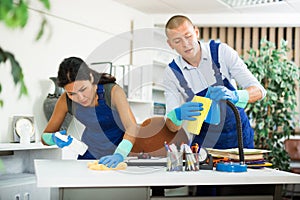 Workers cleaning desk in modern office