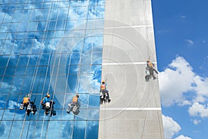 Workers cleaning windows mirror service on high rise building