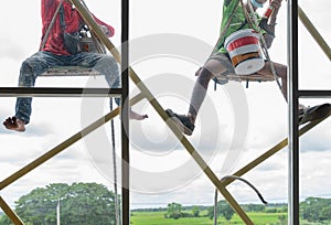 Workers climb on the building to wipe the glass