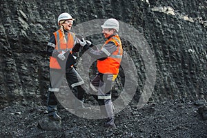 Workers with coal at open pit