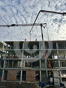 Workers at a construction site against the backdrop of the construction of a high-rise building. Builders work against the